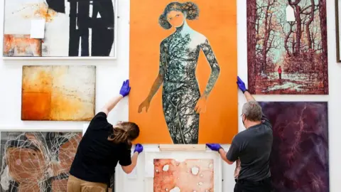 Alice Hendy Hanging artworks for the exhibition