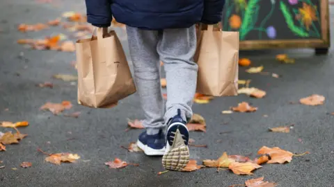 PA Media Child carrying lunch bags