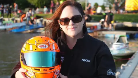 Jamie Niblock/BBC Nikki Mantripp holding a helmet