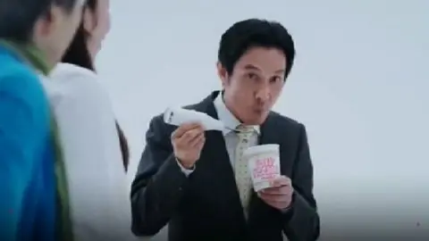 man looking up from his ramen bowl