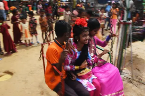 DIBYANGSHU SARKAR/ Getty Images Young Rohingya refugees enjoy a ride on a carousel during Eid Al-Adha festival celebrations.