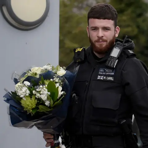 Getty Images police officer with flowers