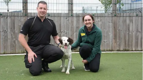Dogs Trust PC Mark West with a dog and charity worker