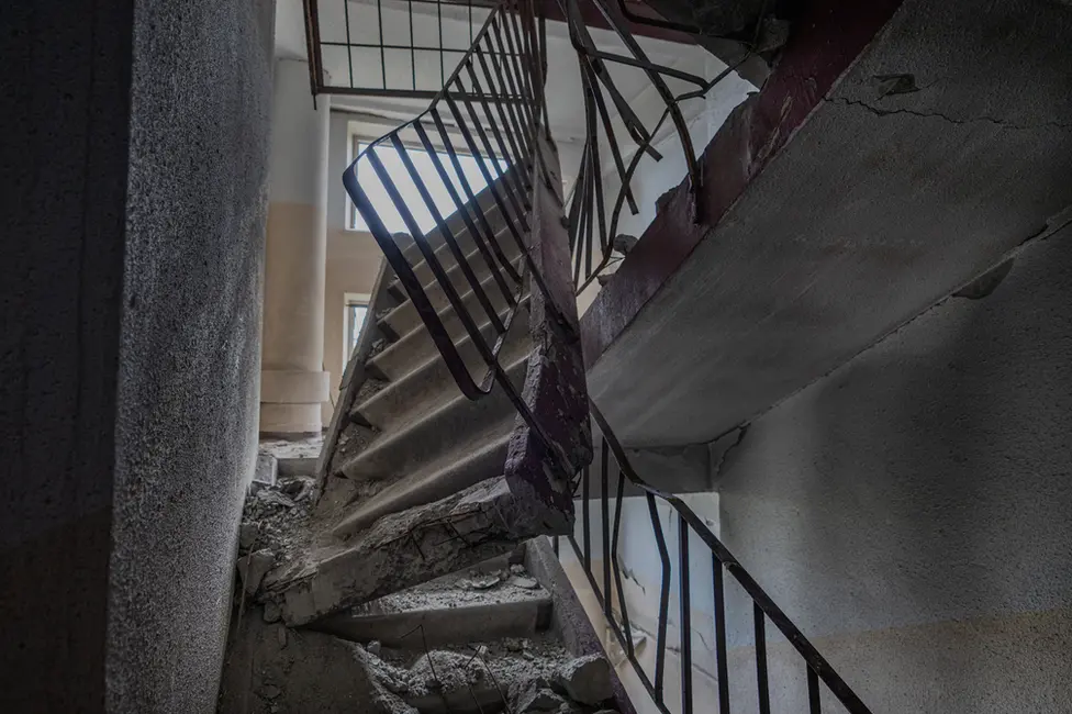 BBC The concrete stairwell two floors above Roman's apartment, smashed by a direct hit on the roof