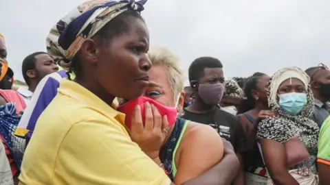 AFP A woman cries as she waits for her son to arrive in Pemba on April 1, 2021, from the boat of evacuees from the coasts of Palma.