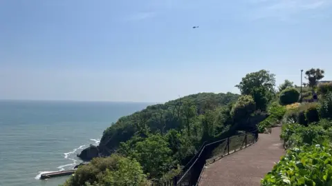 BBC Helicopter in distance on the coast of Oddicombe following a rescue