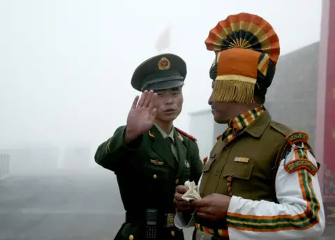 Getty Images In this photograph taken on July 10, 2008, A Chinese soldier gestures as he stands near an Indian soldier on the Chinese side of the ancient Nathu La border crossing between India and China
