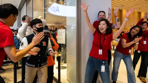 Getty Images Employees applaud as customers enter the new Apple Inc. store inside the Starfield mall during its opening in Hanam, South Korea, on Saturday, Dec. 9, 2023.