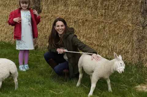 PA Media Catherine holds a lamb on a lead