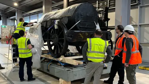 National Railway Museum Workmen pull plastic sheets off the Rocket