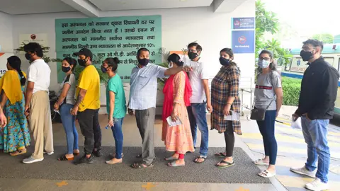 Getty Images People queue to receive vaccines in Delhi, India on 6 June