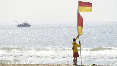 PA Media Lifeguard with a red and yellow flag