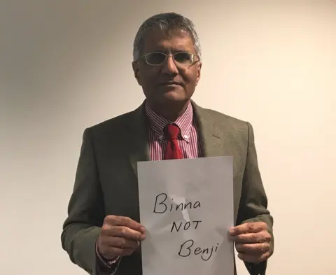Binna Kandola Binna Kandola holding up a sign saying "Binna NOT Benji"