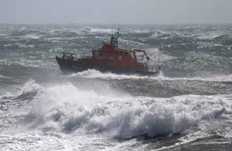 PA Media A lifeboat on rough sea