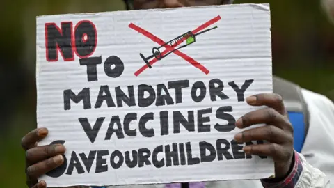 Getty Images A protester holds up an anti-vaccine placard