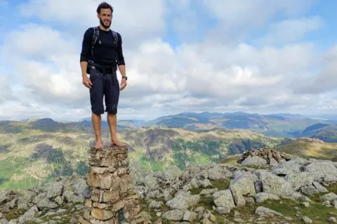 Matt Scott Matt Scott stands on top of a trig point in barefoot