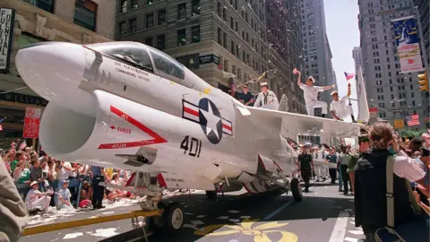 AFP A Navy A-7 Corsair jet is pulled down Broadway Avenue as sailors rejoice on the wings during the Operation Welcome Home ticker-tape parade during the 10 June 1991 celebration for returning Gulf War troops