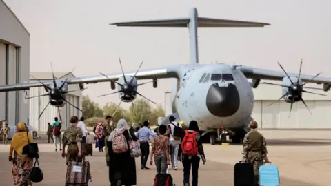 Reuters British nationals walk to board an RAF aircraft during the evacuation to Cyprus, at Wadi Seidna airport, Sudan