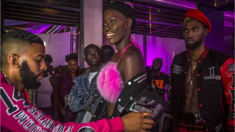 Marta Moreiras US designer and fashion stylist Mickey Freeman (left) adds his special touch to his creations at Dakar Fashion Week in Dakar, Senegal