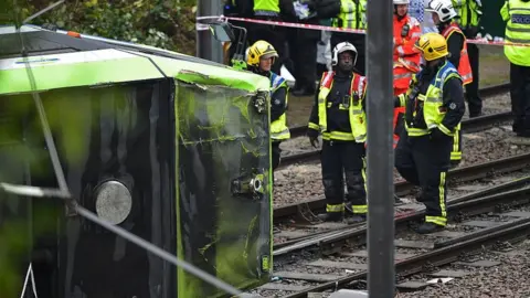 Getty Images Members of London Fire Brigade look at the overturned tram