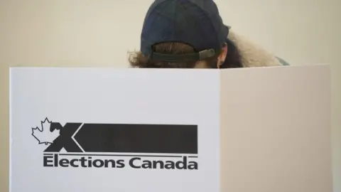 Canadian Press A voter casts a ballot behind an 'Elections Canada' sign.