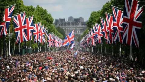 Reuters Thousands of people on the Mall in central London, with hundreds of Union flags lining the road