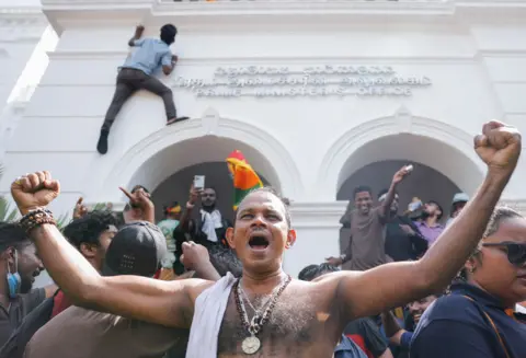 DINUKA LIYANAWATTE / REUTERS Demonstrators celebrate after they entered into Sri Lankan Prime Minister Ranil Wickremasinghe's office during a protest demanding his resignation in Colombo, Sri Lanka, 13 July 2022.