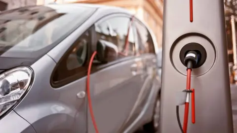 Getty Images An electric car charging on the street.