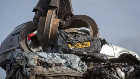 Getty Images Car in claw at scrapyard