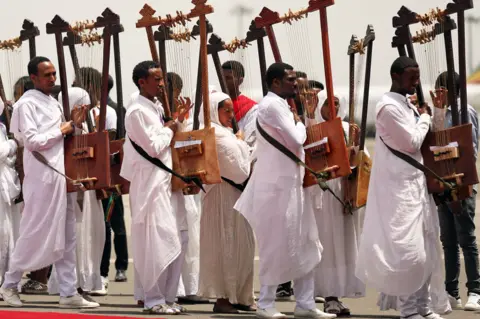 Reuters Choir members play harps during a welcome ceremony Bishop Merkorios upon returning from exile at the Bole airport in Addis Ababa, Ethiopia - Wednesday 1 August 2018