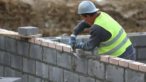 Getty Images Man building a home