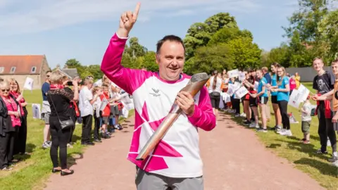 Getty Images Baton bearer Stuart Johnson at Kinneil House in Bo'ness