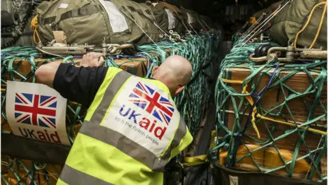 MOD File pic of a UK aid worker loading an RAF plane with supplies