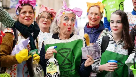 PA Media Protesters in Glasgow with fake cleaning products branded as "greenwashing"