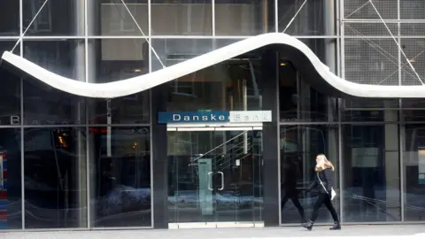 Reuters Woman walks past Danske Bank branch