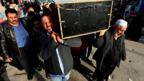AFP Iraqis carry the coffin of a victim during a funeral in the holy city of Najaf, Iraq, 15 January