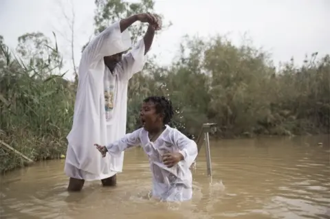 EPA Pilgrims from Ethiopia dip at the Qasr al-Yahud baptism site in the Jordan River, West Bank near Jericho, 29 November 2018.