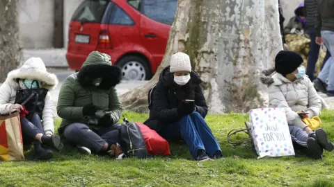 EPA Croatians wear face masks as they sit outside