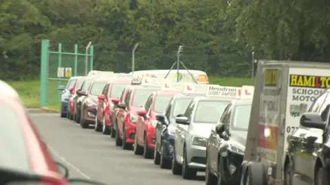 dozens of driving instructors staged a protest outside the DVA test site in Craigavon on Tuesday morning over the continued closure of driving test services at the site.