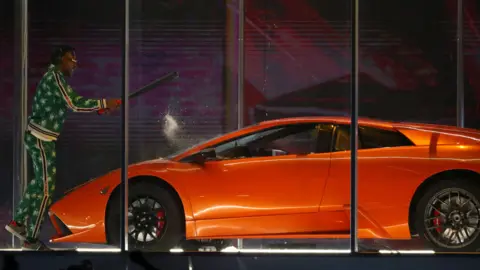 Reuters A performer attacking a car during Kendrick Lamar's performance