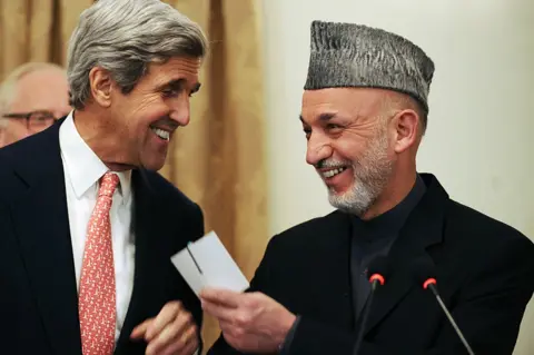 Shah Marai / AFP US Senator John Kerry laugh with Afghan President Hamid Karzai at a press conference at the presidential palace in Kabul, 20 October 2009