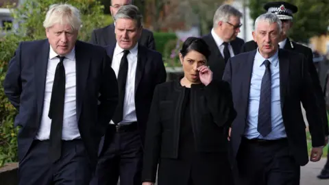 Andrew Parsons / No10 Downing Street HANDOUT Commons Speaker Sir Lindsay Hoyle joined Prime Minister Boris Johnson, Labour leader Sir Keir Starmer and Home Secretary Priti Patel as they laid floral tributes to Sir David Amess at Belfairs Methodist Church, in Leigh-on-Sea, where he was fatally stabbed.