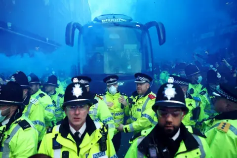 Carl Recine / Reuters Police officers are seen in front of the Everton team bus outside the stadium before the match
