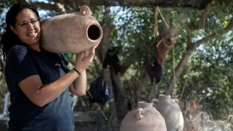 Reuters Archaeologist carries Gaza Jar at the site