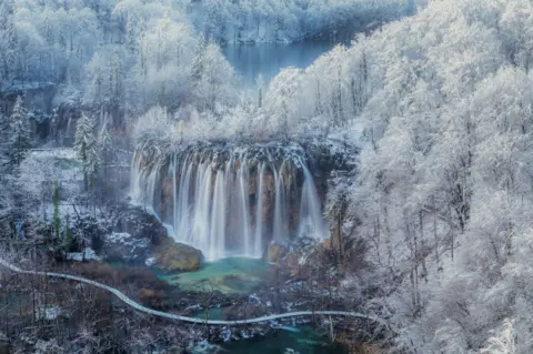 Jaka Ivancic A snow-covered forest and a waterfall