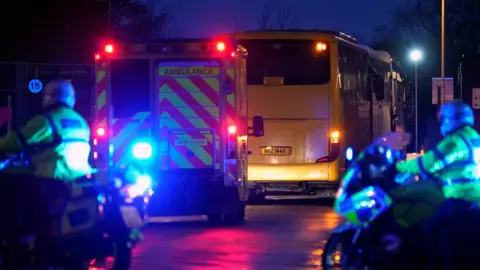Getty Images Coaches carrying the passengers arrived at Arrowe Park hospital, accompanied by police