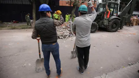 BBC Workers were regularly interrupted from clearing debris by shouts of "¡silencio!" as rescuers used sensitive instruments to try and find victims of the 7.1 magnitude earthquake, Mexico City, 20 September 2017