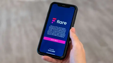 Northamptonshire Police Woman holding a phone showing the Flare Report app on screen