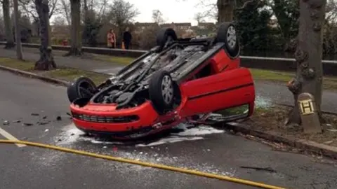 Derbyshire Roads Policing Unit A red Vauxhall Corsa on its roof