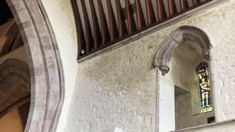 dark patch below an arch in Brecon cathedral